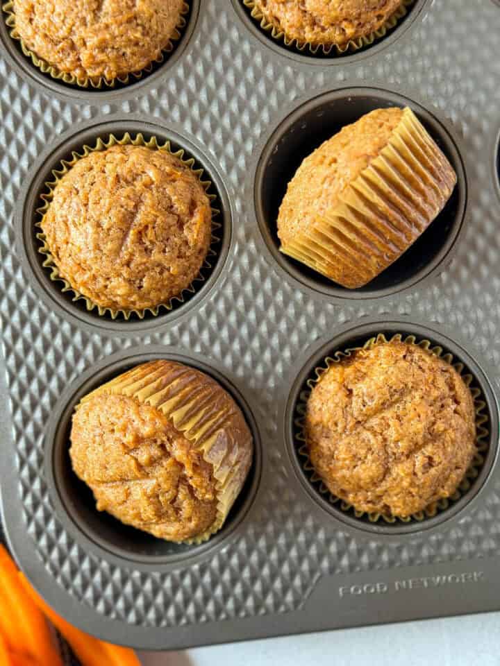 Close up top view of applesauce carrot muffins in pan.