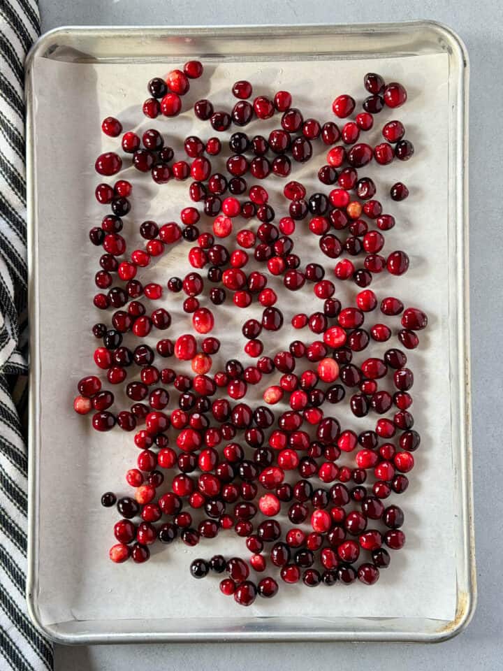 Drained cranberries on parchment lined sheet pan.