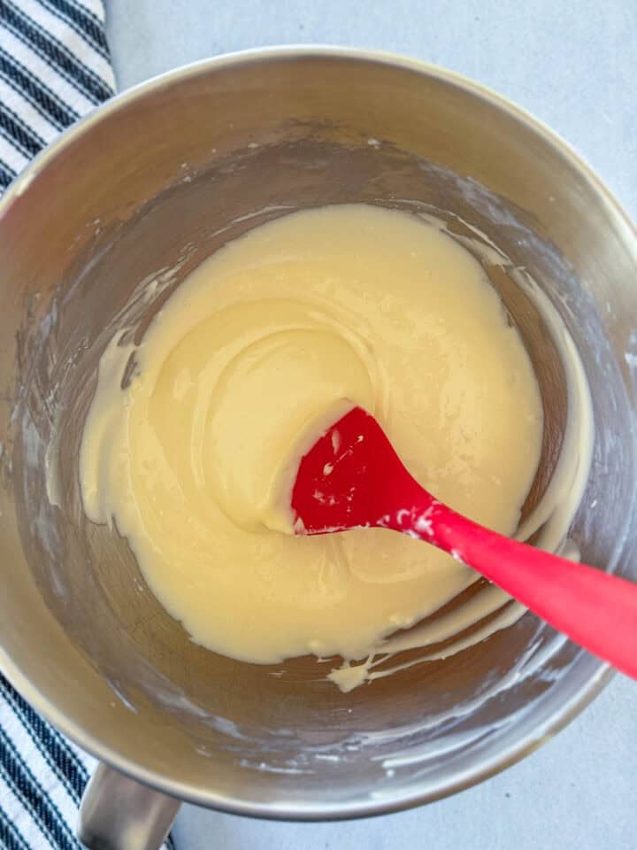 Egg and vanilla added to cream cheese mixture in mixing bowl.