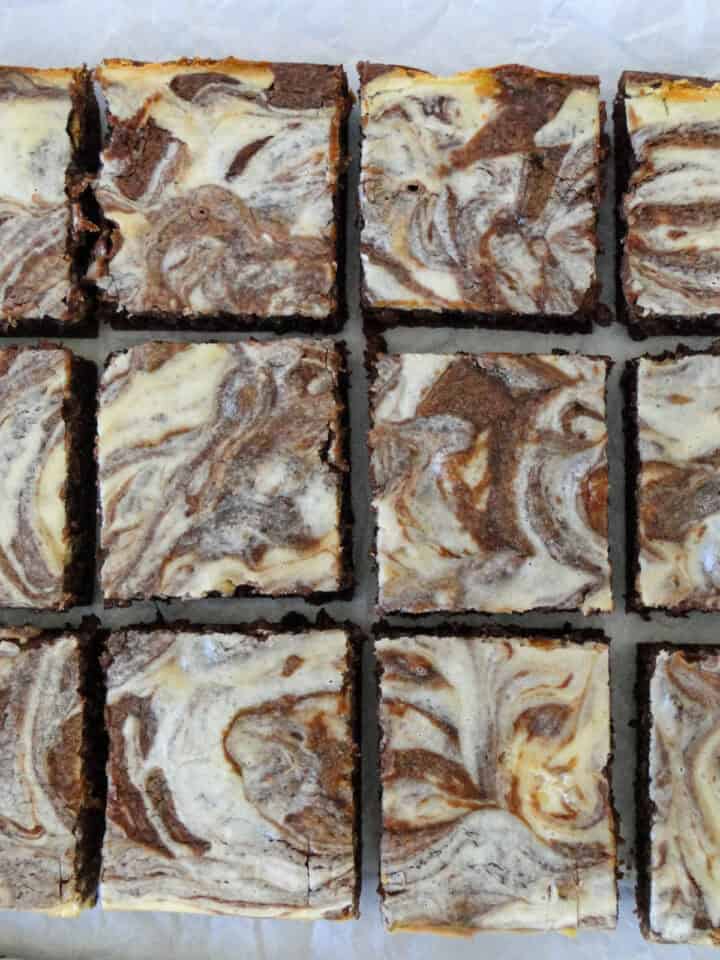 Top view of six cheesecake swirl brownies in two columns.