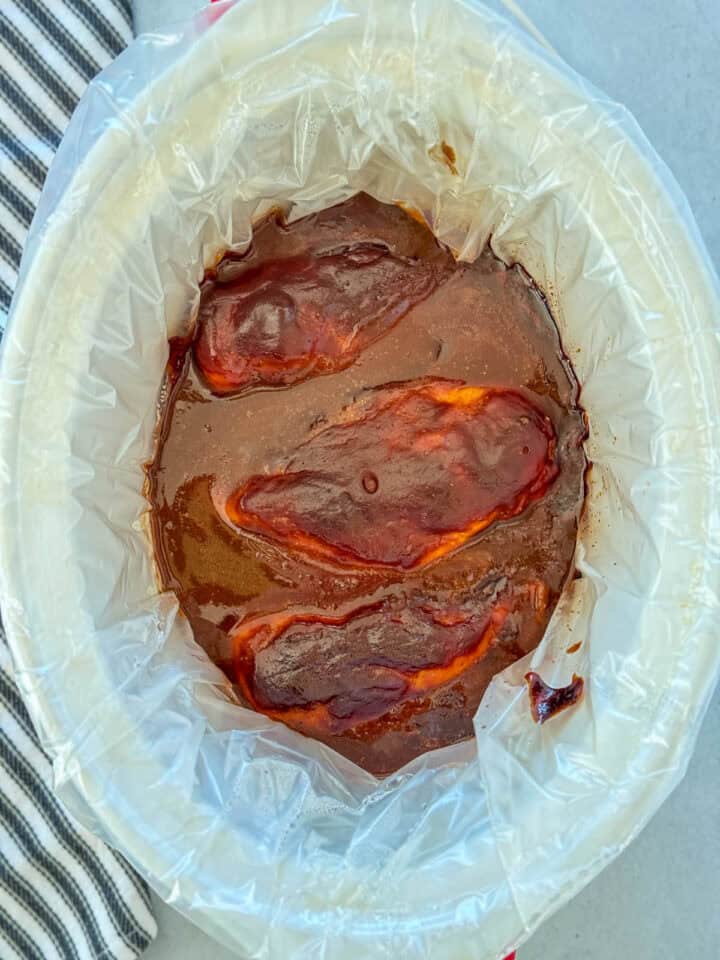 Cooked chicken breast in bbq sauce in crock pot.