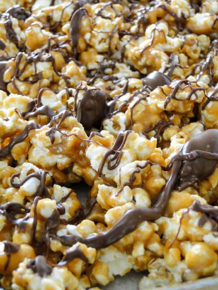 Close up side view of scotcharoo popcorn spread out on sheet pan.