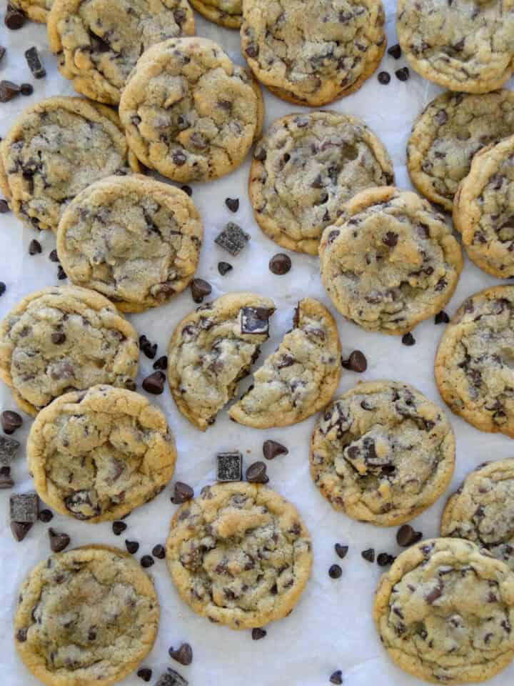 Triple chocolate chip cookies staggered and layered on parchment paper.