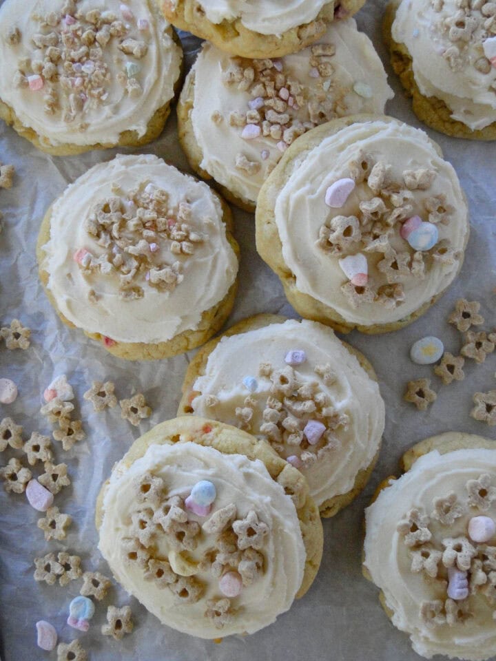 Top view of frosted lucky cookies piled on parchment paper.