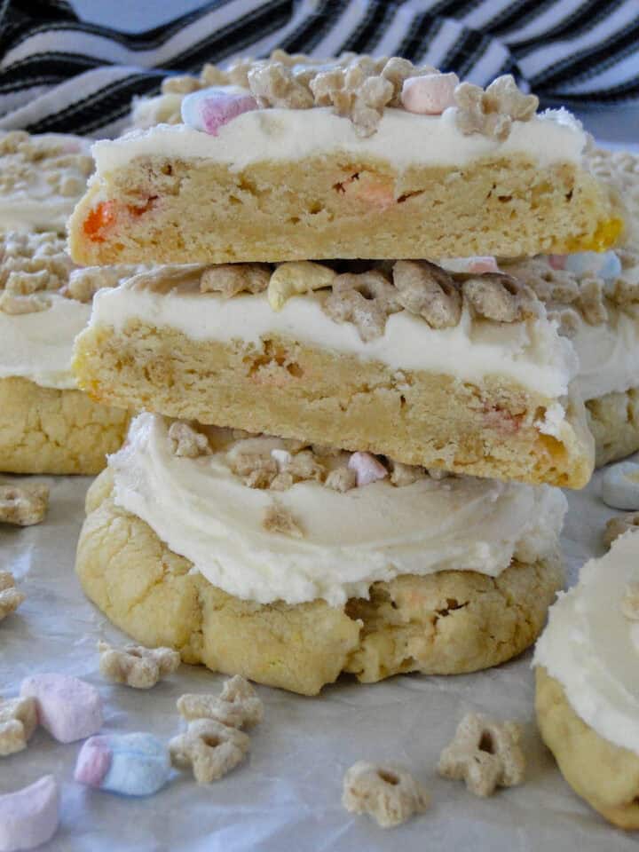 Two frosted lucky cookies stacked with top cookie cut in half stacked showing center of cookie.