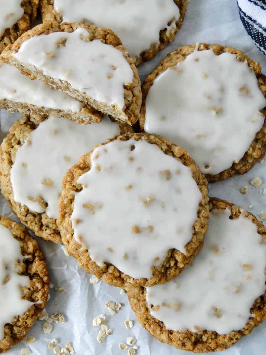 Close up top view of iced oatmeal cookies in pile with focus on top cookie.