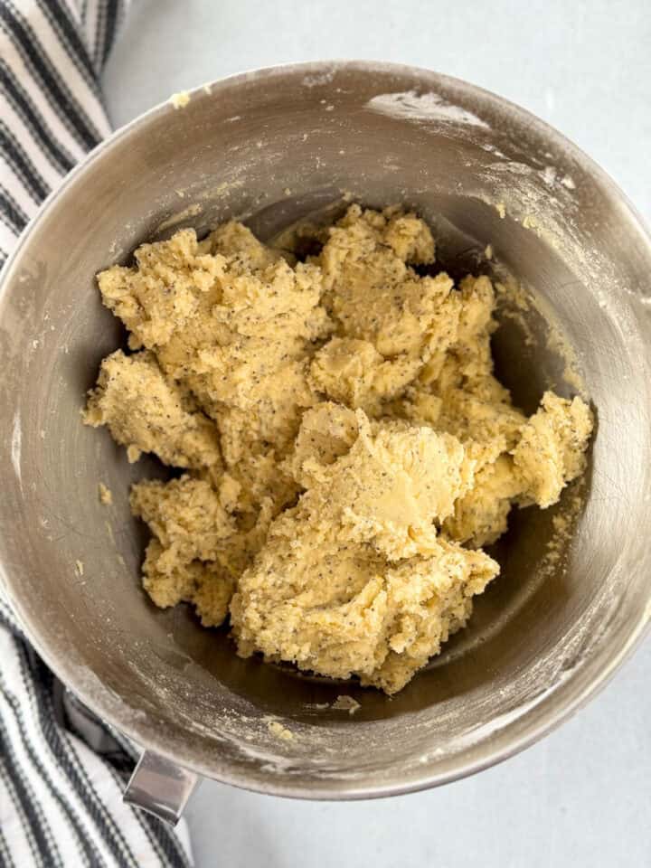 Dry ingredients mixed into wet ingredients in large metal mixing bowl.