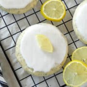 Top view of lemon poppy seed cookie on wire rack with lemon slices to the right of cookie.