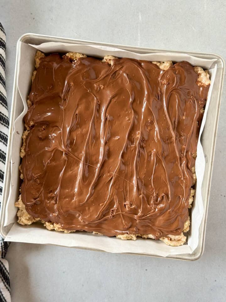 Melted chocolate chips spread over s'mores bars.