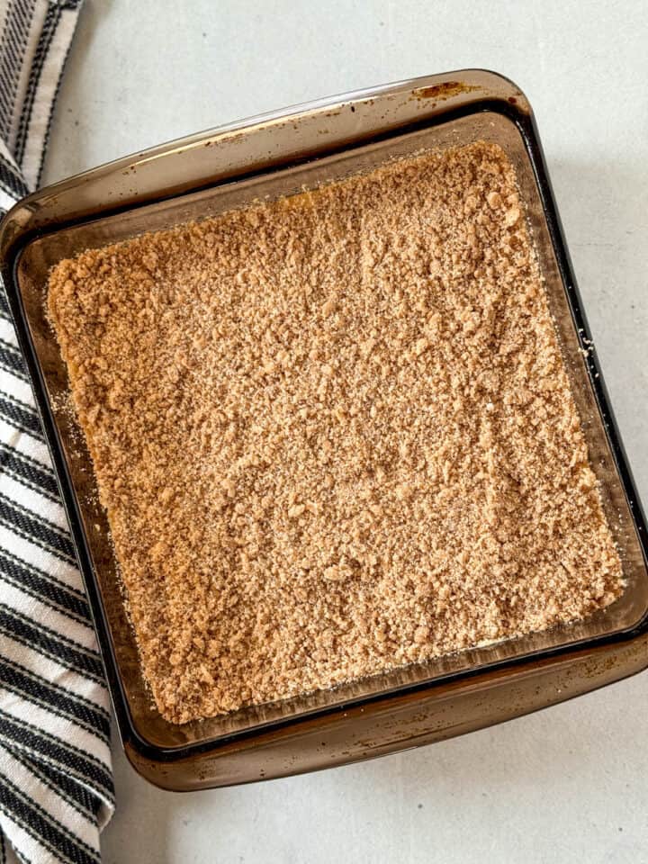 Crumble topping added on top of batter in glass baking dish.