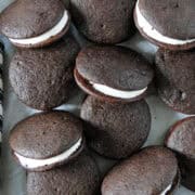 Close up top view of whoopie pies scattered and staggered on parchment paper.