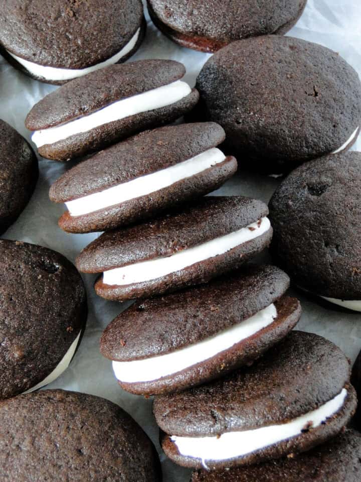 Top view of chocolate whoopie pies on their side in a row surrounded by more whoopie pies.