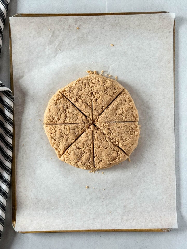 Dough cut into 8 triangles on parchment line sheet pan.