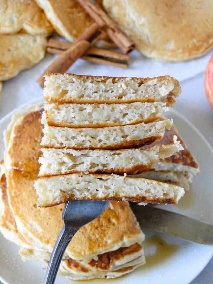 Close up view of apple pancakes bite on fork.