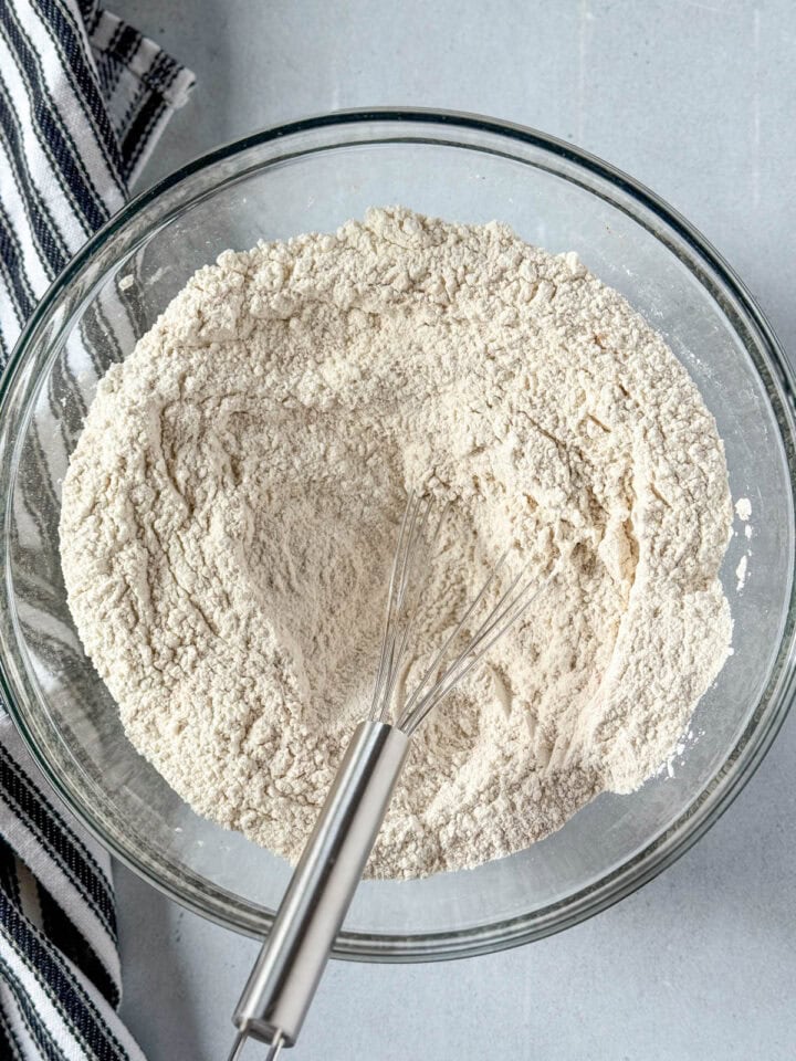 Dry ingredients whisked together in large glass mixing bowl with whisk.