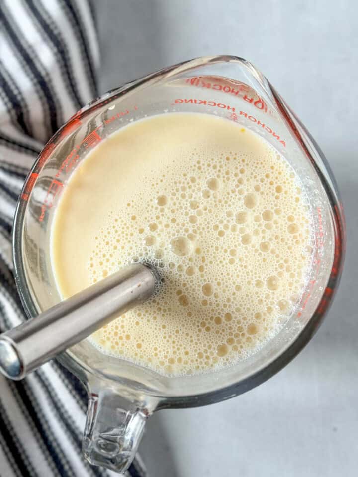 Wet ingredients whisked together in large glass measuring cup with whisk.