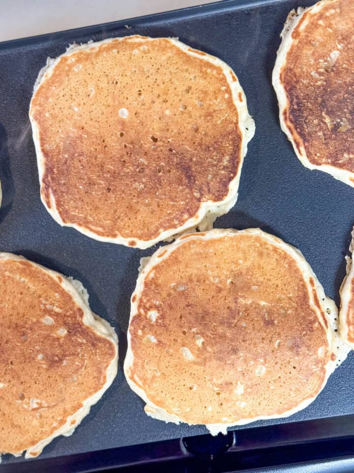 Pancakes flipped on griddle.