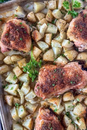 Top view of one pan chicken and potatoes on sheet pan.