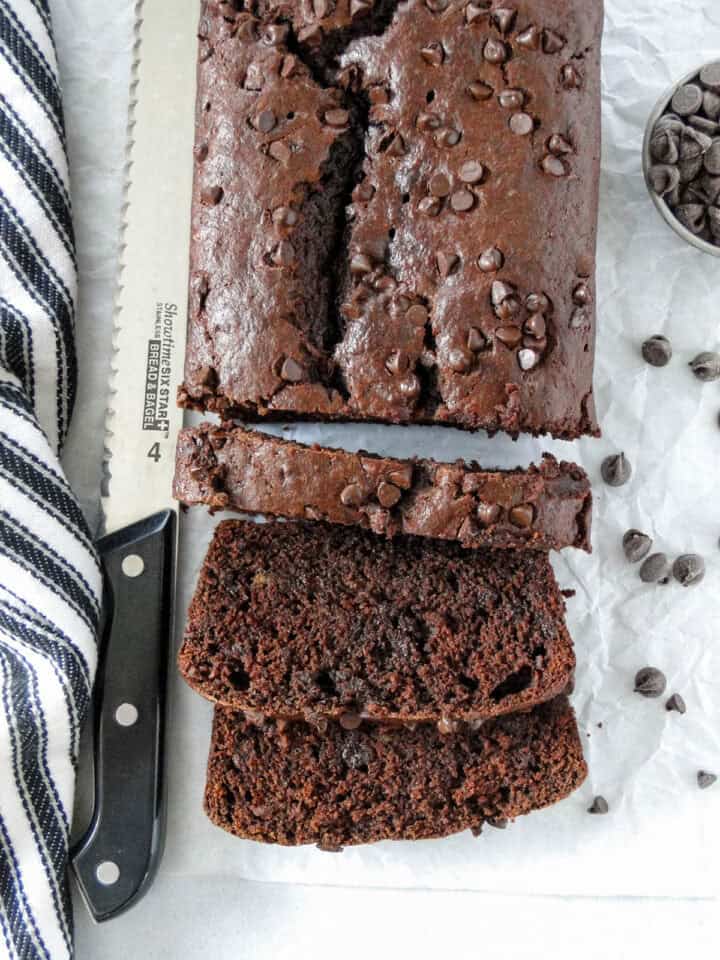 Top view of double chocolate banana bread loaf with 3 slices cut from it.
