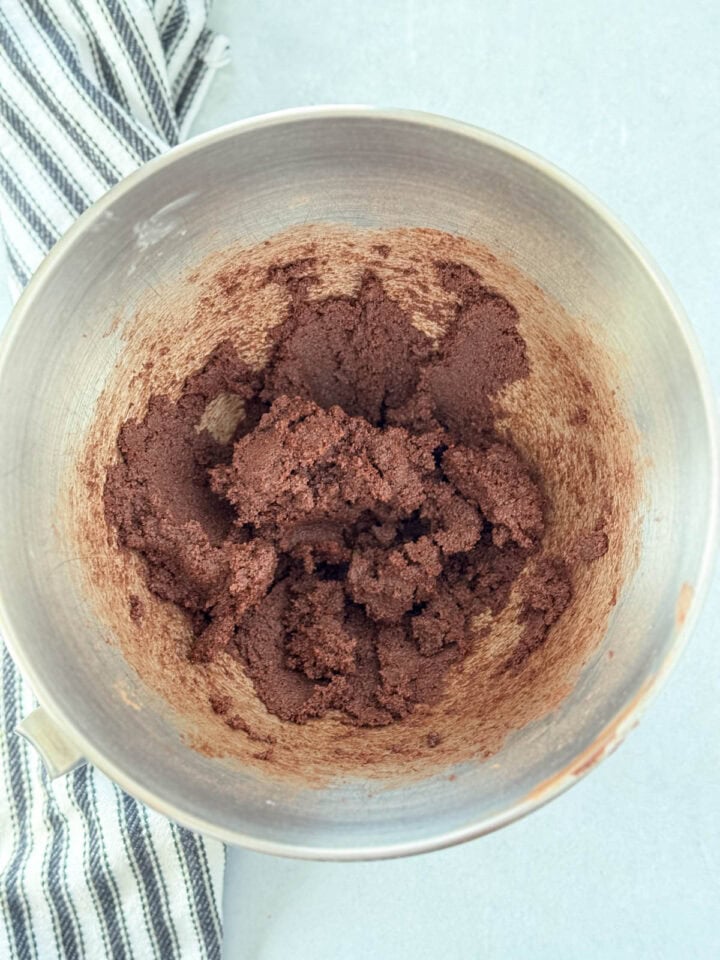 Butter, sugars and cocoa powder creamed together in large metal mixing bowl.