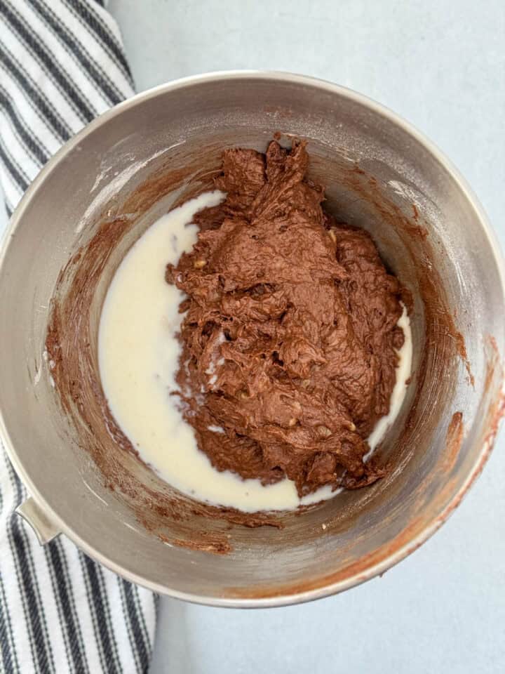 Milk adding to bread batter in large mixing bowl.