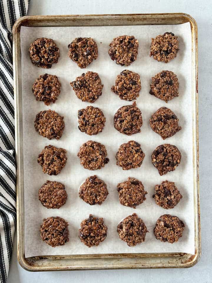 Cookies scooped into rows on parchment lined sheet pan.