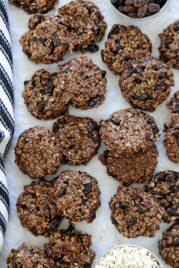 Top view of no bake chocolate cookies staggered and piled on parchment paper.