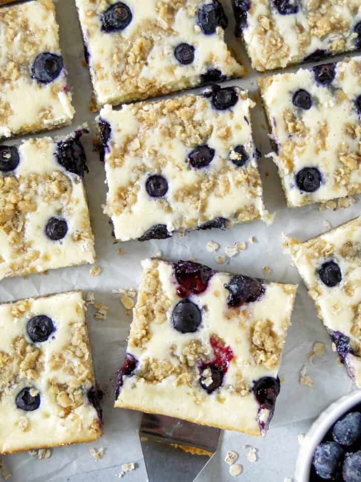 Close up top view of blueberry cream cheese bars sliced and spatula under one bar.