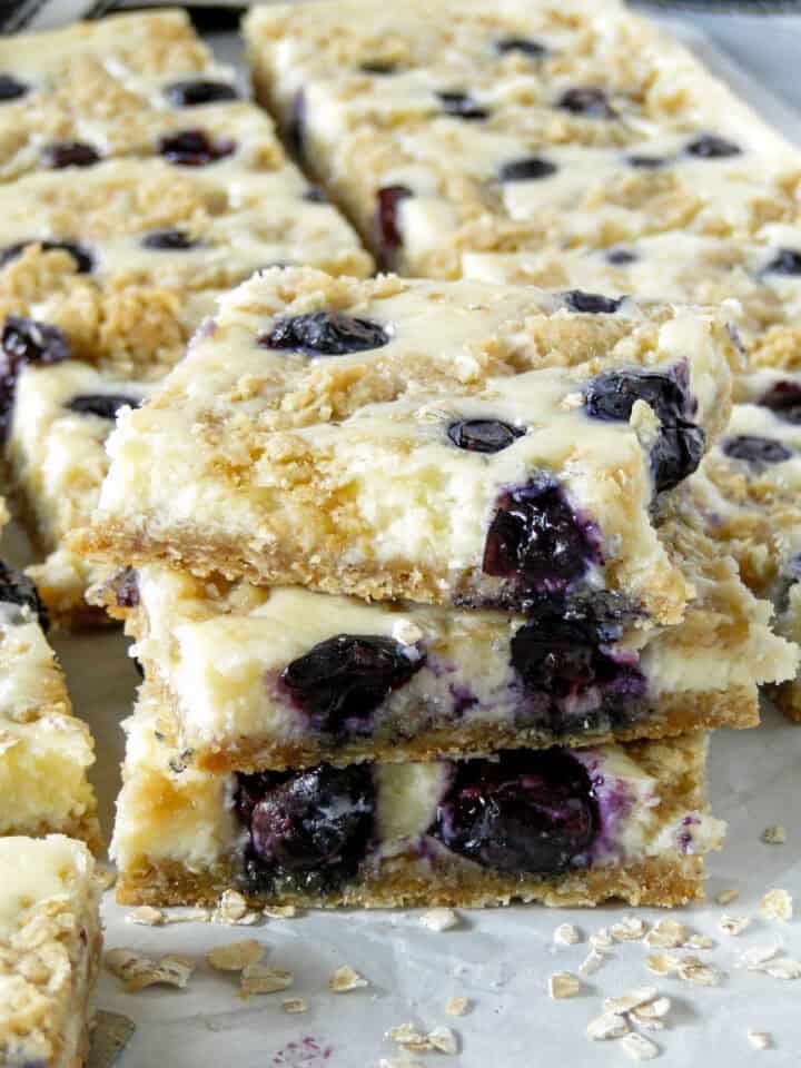 Close up side view of 3 blueberry cream cheese bars stacked.