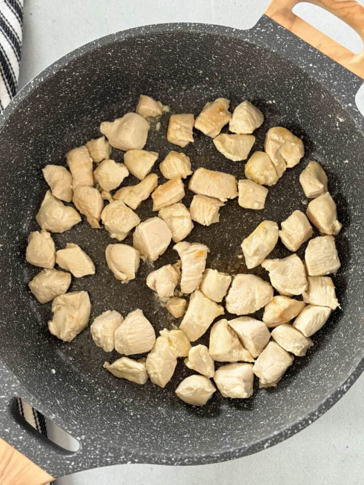 Diced chicken cooked in large skillet.