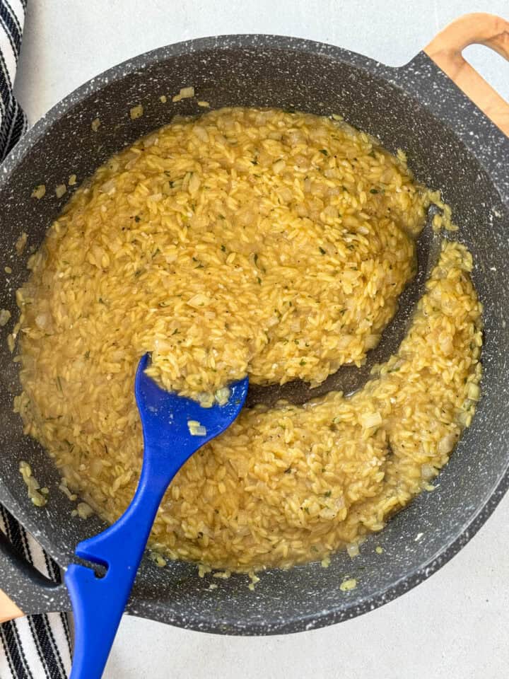 Orzo cooked half way in skillet.