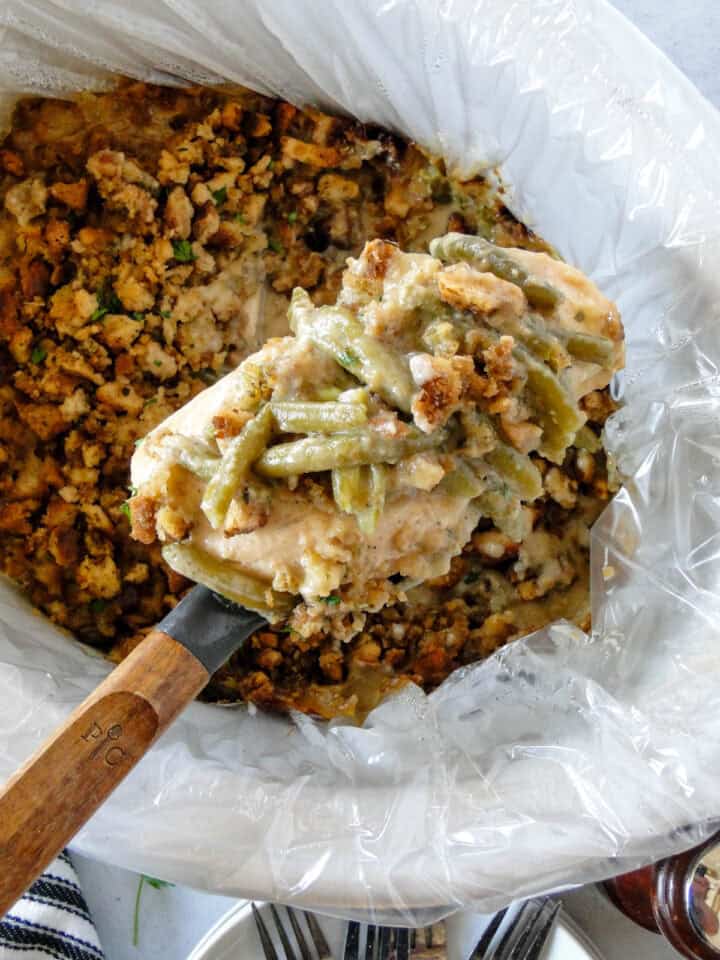 Crock pot chicken and stuffing being served out of crock pot on serving spoon.