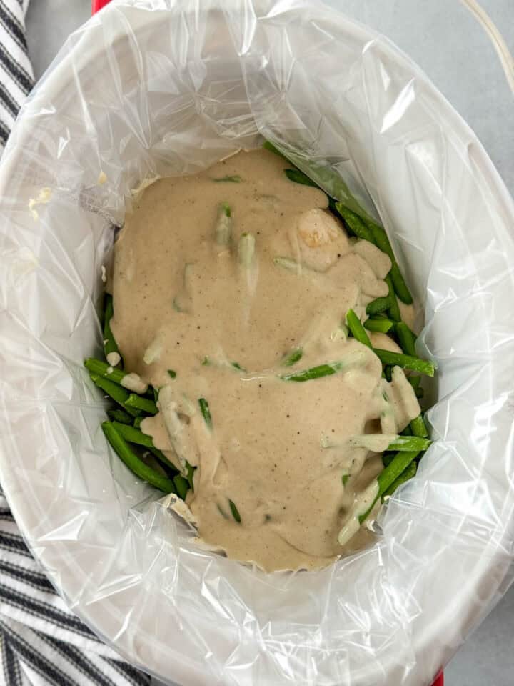 Gravy poured over chicken and green beans in crock pot.