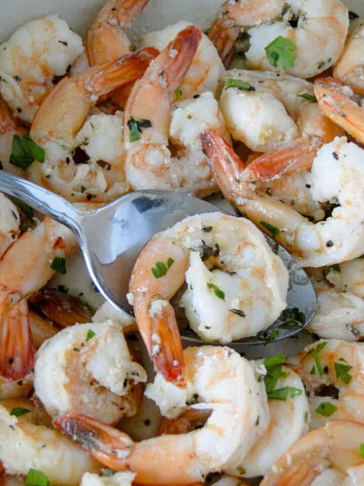 Close up view of garlic butter shrimp on serving spoon.