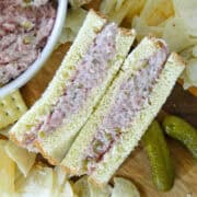 Easy ham salad recipe between slices of bread cut in half and set up to see inside of sandwich.