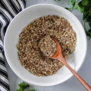 Homemade onion soup mix in white round bowl with mini wooden spoon.