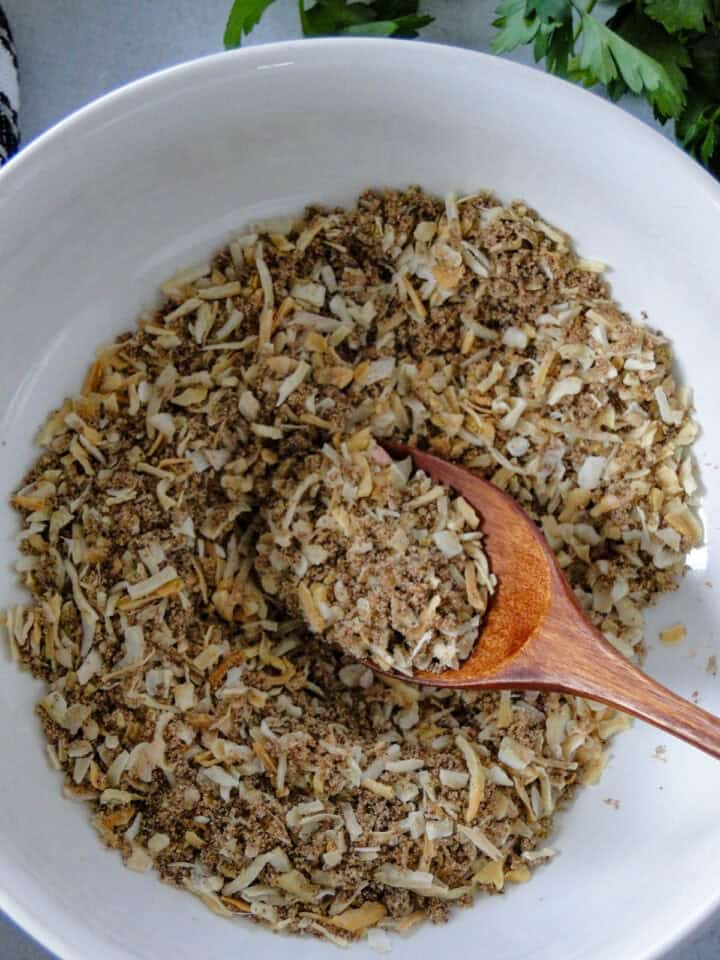 Top view of homemade onion soup mix in white round bowl.