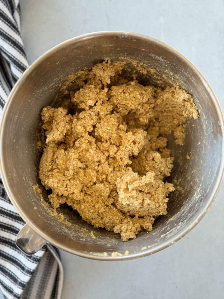 Dry ingredients added to wet in large metal mixing bowl.