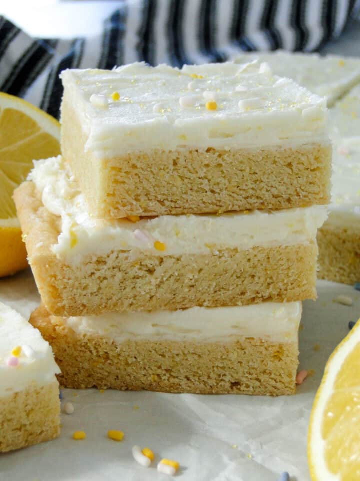Close up side view of three sliced lemon cookie bars stacked.