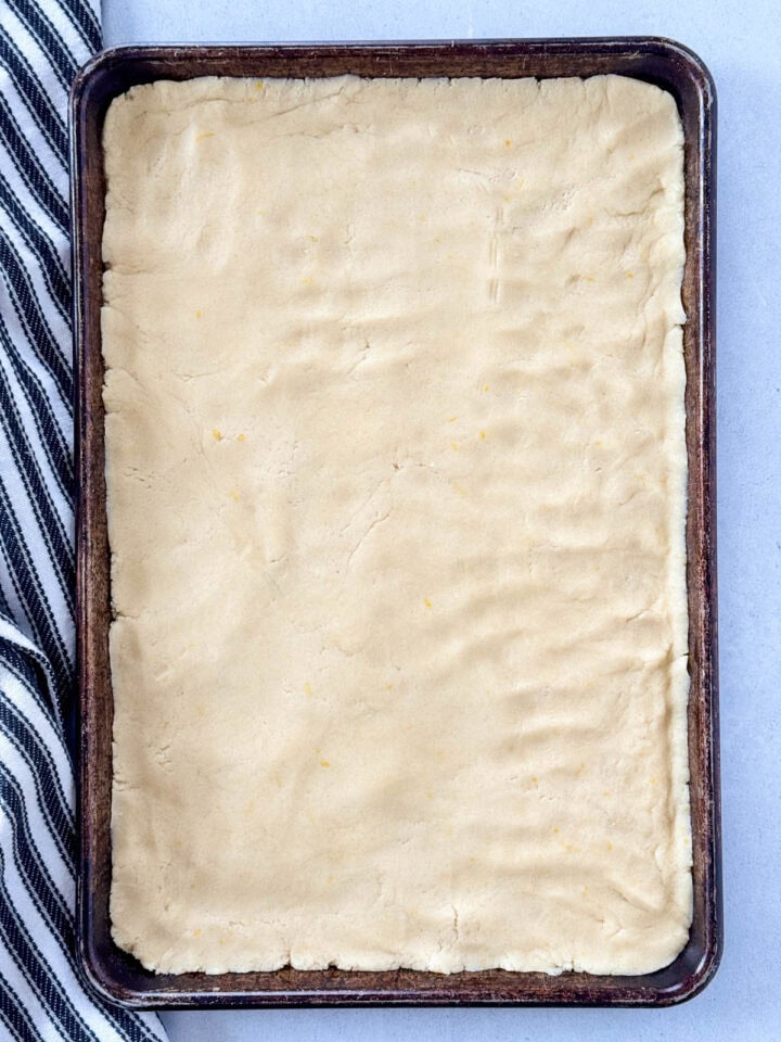 Cookie dough spread out into sheet pan.