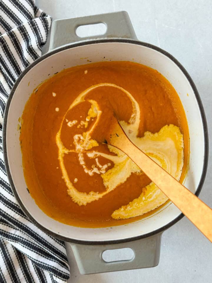 Cream added to blended soup in dutch oven.