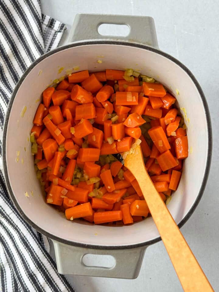 Veggies cooked in dutch oven with wood stirring spoon.