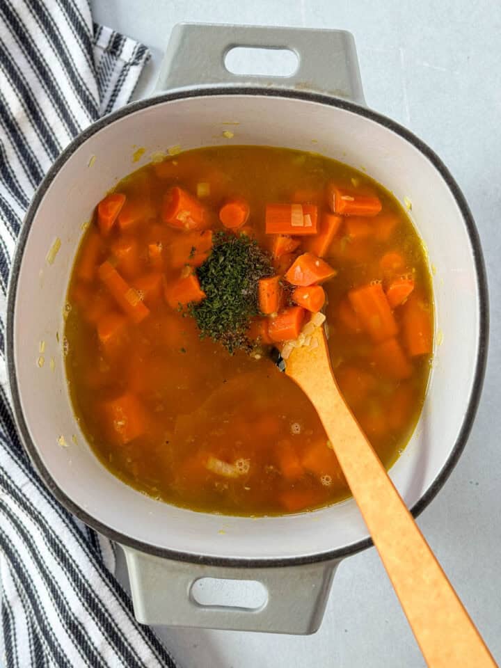 Chicken broth and seasonings added to sauteed veggies in dutch oven.
