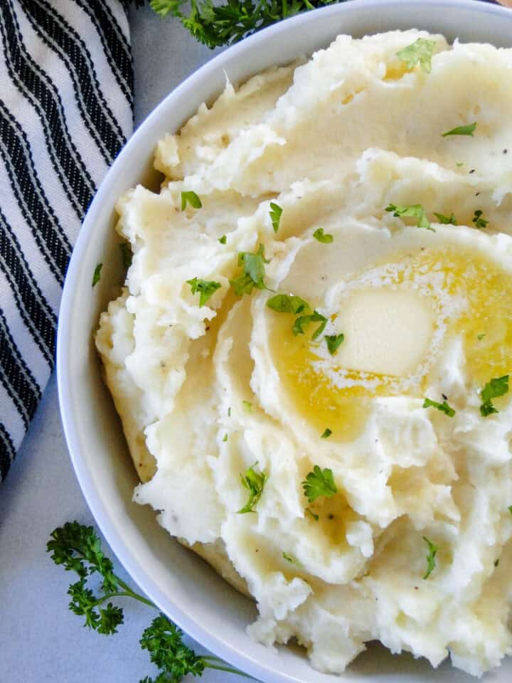Close up top view of instant pot mashed potatoes in white serving bowl.