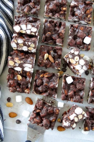 Top view of no bake rocky road bars scattered and layered on parchment paper.