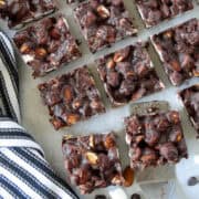 Top view of sliced no bake rocky road bars in rows with one bar on a mini spatula.