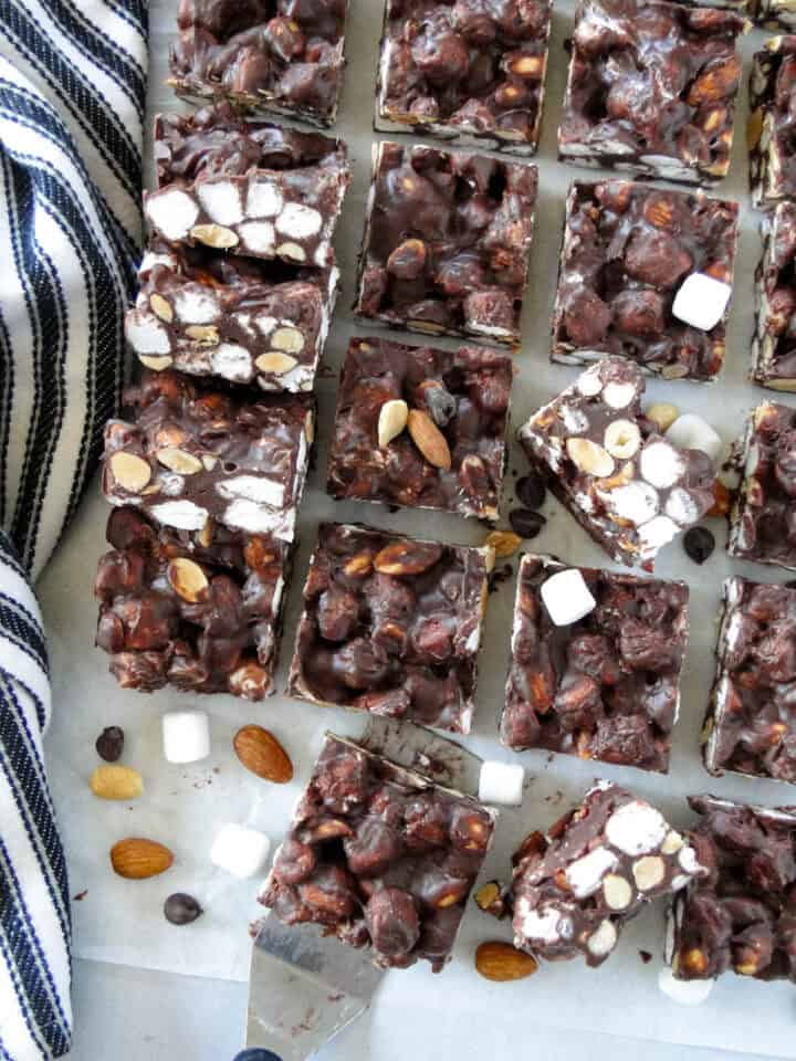Top view of no bake rocky road bars scattered and layered on parchment paper.