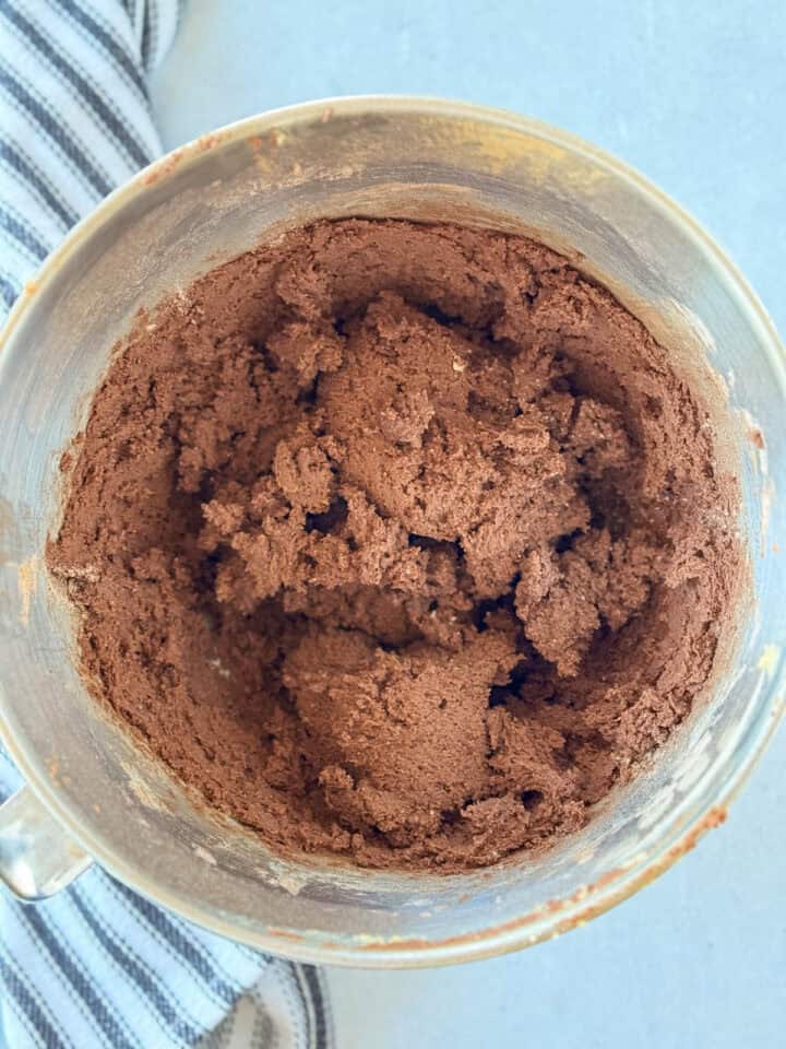 Dry ingredients mixed into wet in metal mixing bowl.