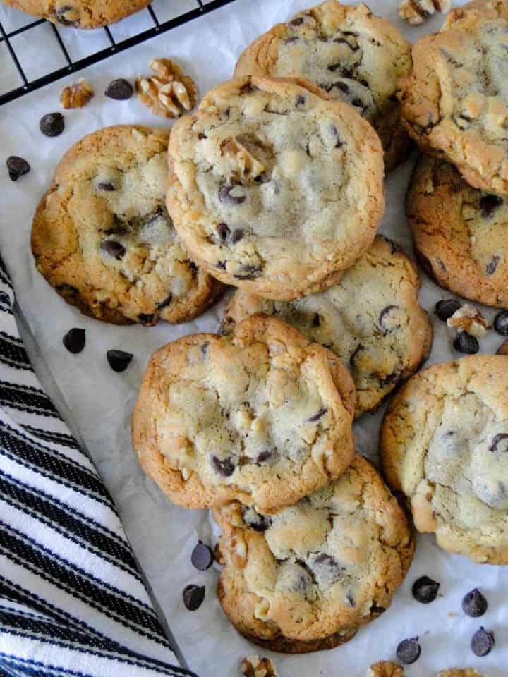 Top view of chocolate chip walnut cookies piled on parchment paper.