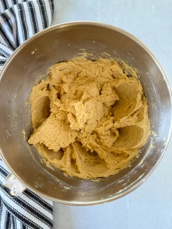 Eggs and vanilla extract added to creamed butter and sugars in large mixing bowl.